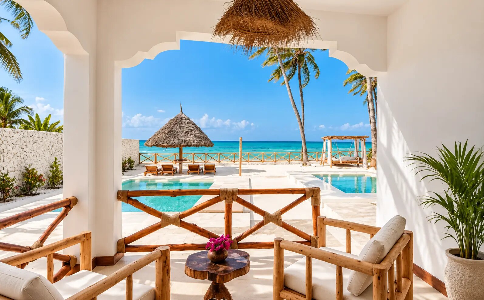 The villa's arched veranda looking out over the pools towards the beach