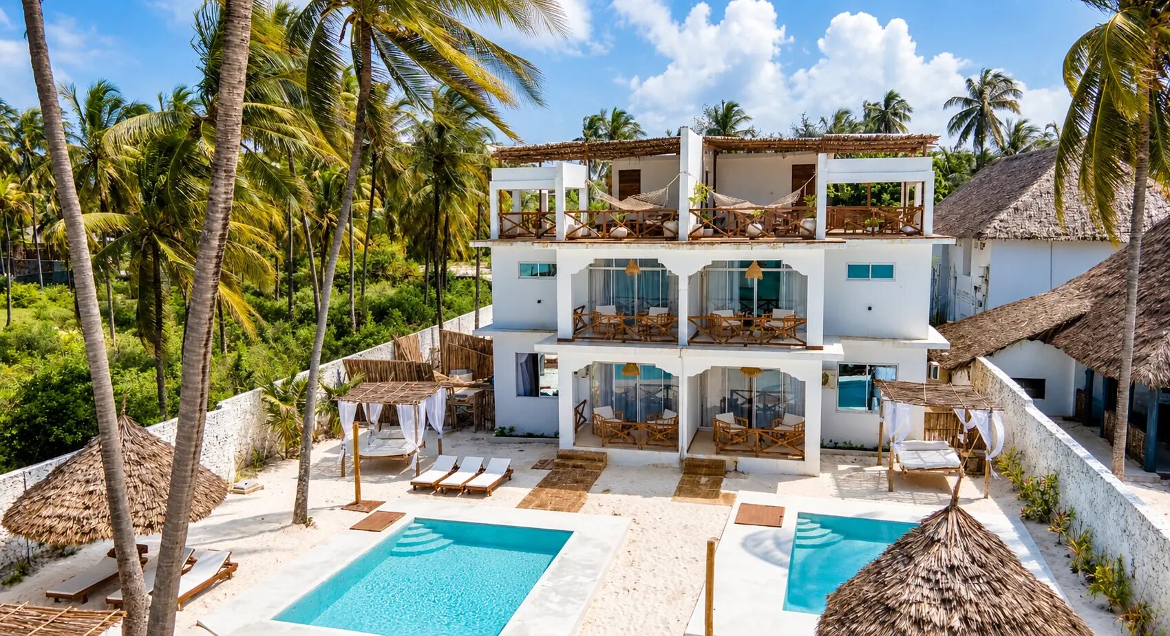 The white villa and its two pools seen from the garden