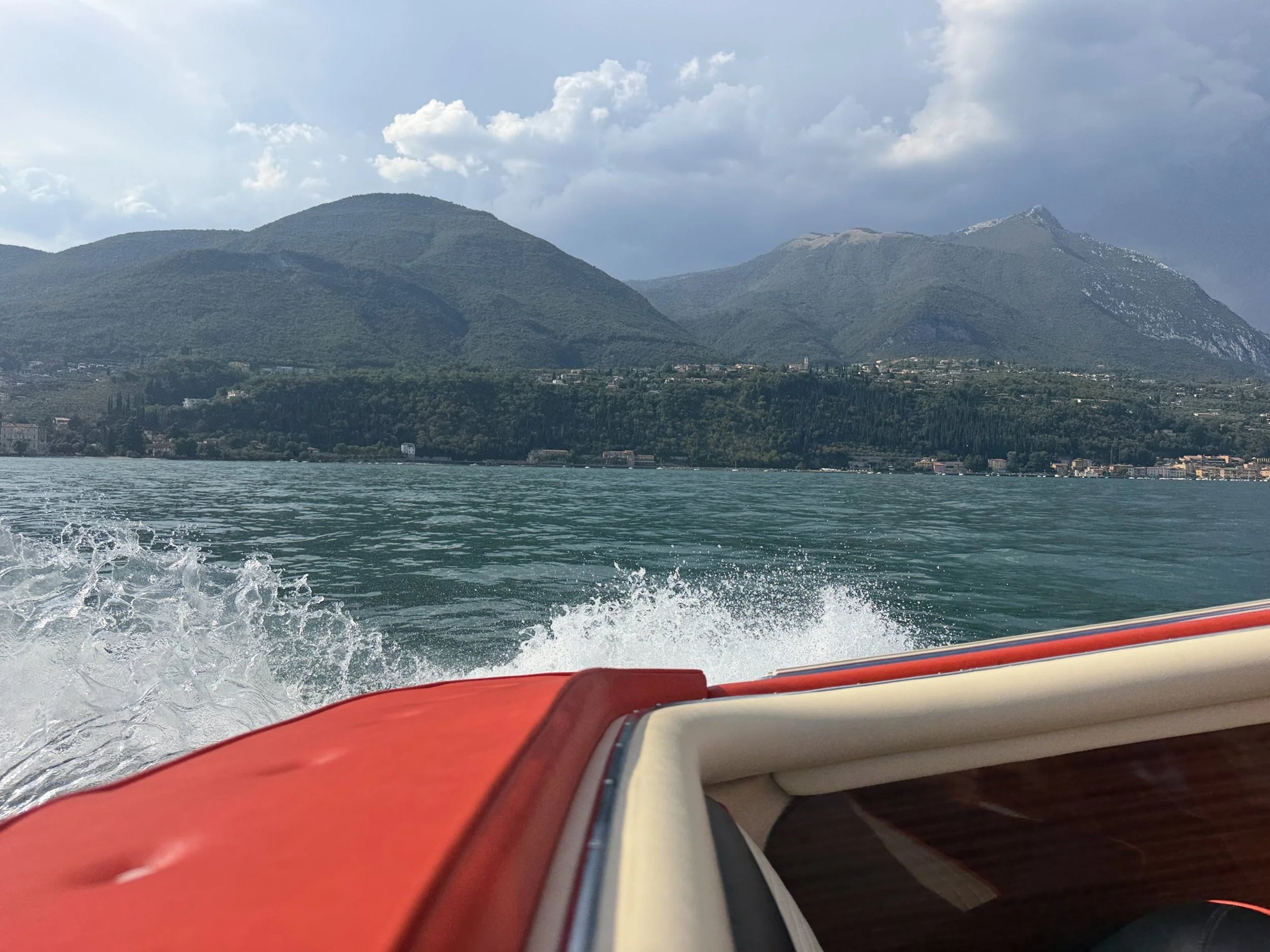 Racing across the lake by boat beneath the mountains