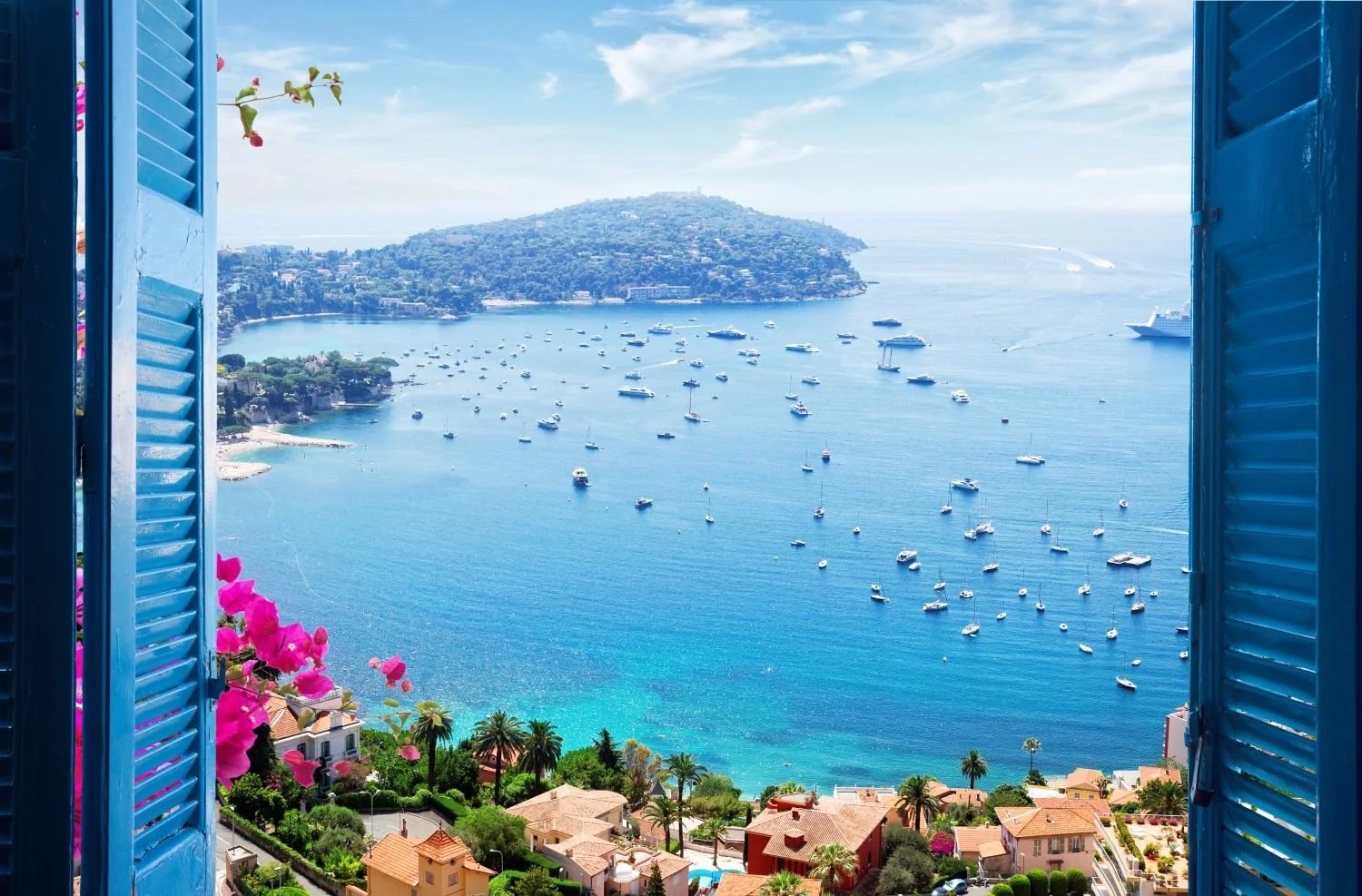 Turquoise bay framed by blue shutters and bougainvillea