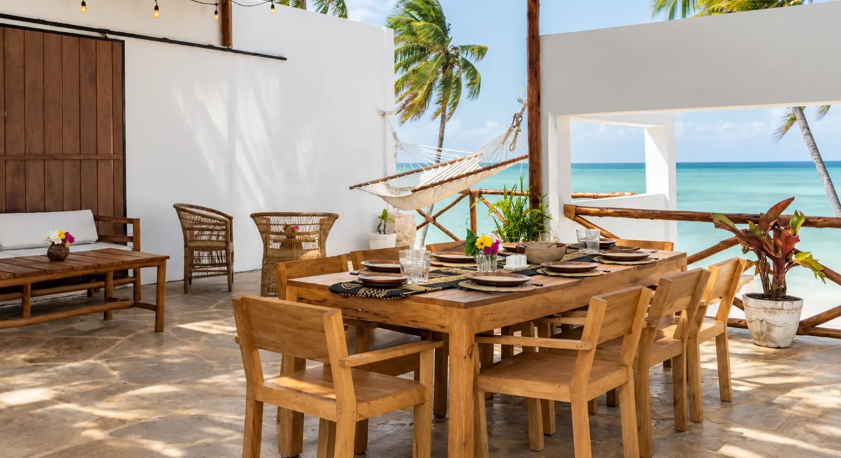Long wooden dining table dressed for dinner on the terrace